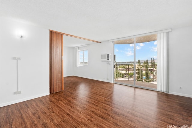 empty room with a textured ceiling and dark hardwood / wood-style floors