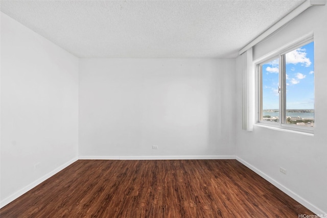 98-1038 Moanalua Rd Unit 1102, Aiea, HI 96701 - spare room featuring a textured ceiling, dark wood finished floors, and baseboards