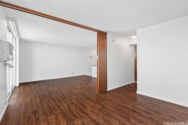 empty room with dark hardwood / wood-style flooring and a textured ceiling