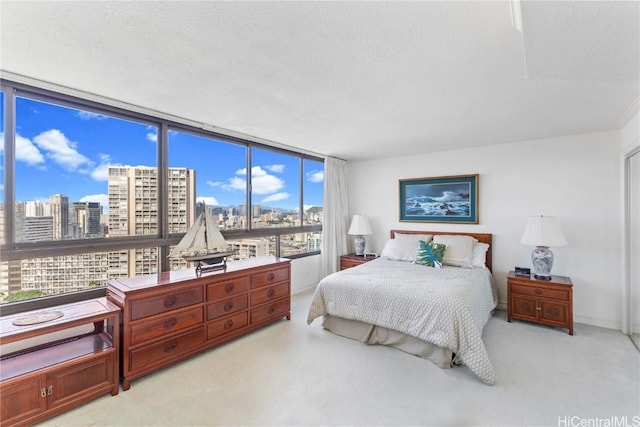 bedroom featuring light colored carpet and a textured ceiling