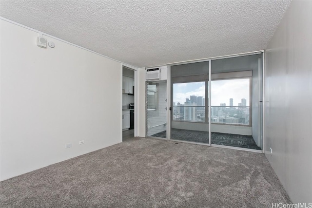 unfurnished bedroom featuring a wall mounted air conditioner, a textured ceiling, and carpet flooring