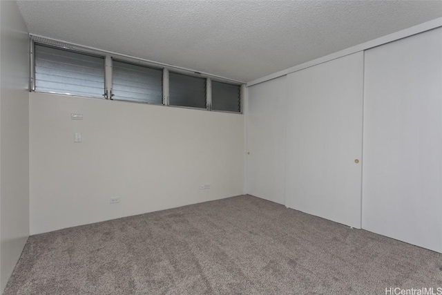 empty room featuring a textured ceiling and carpet flooring