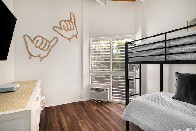 bedroom with a high ceiling and dark wood-type flooring