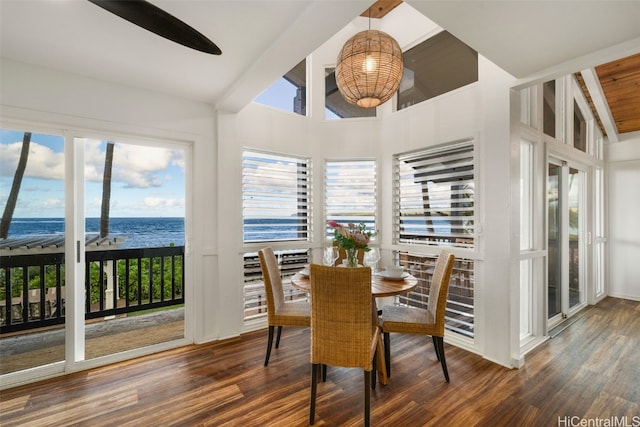 sunroom / solarium featuring lofted ceiling with beams and a water view