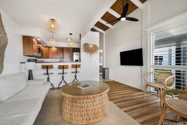 living room with vaulted ceiling with beams, dark hardwood / wood-style floors, and ceiling fan