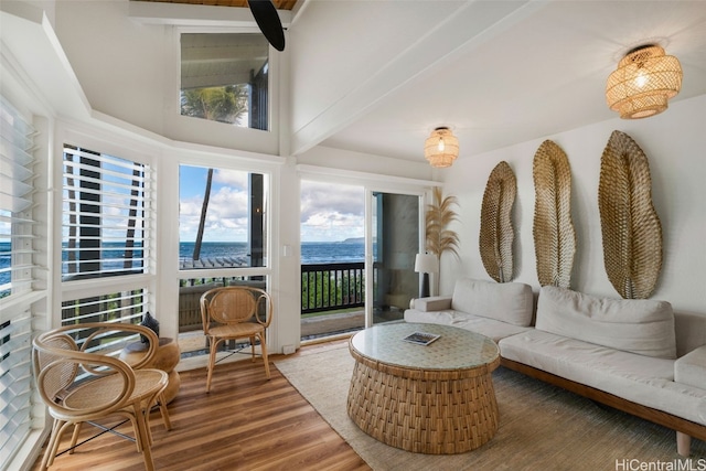 sunroom / solarium with beamed ceiling and a water view