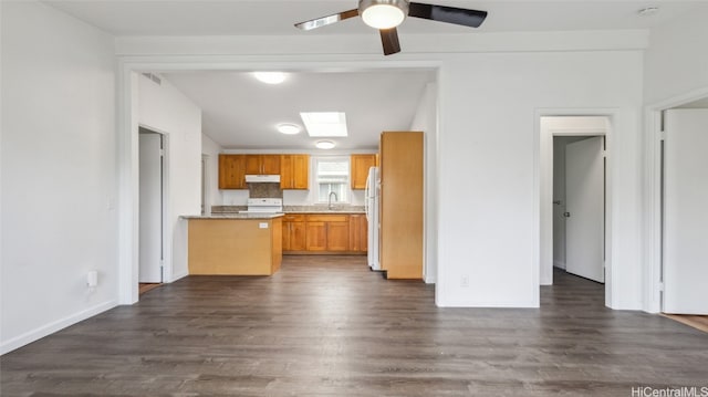 kitchen with decorative backsplash, ceiling fan, white fridge, and dark wood-type flooring