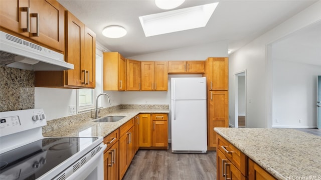 kitchen featuring light stone countertops, white appliances, dark hardwood / wood-style floors, and sink