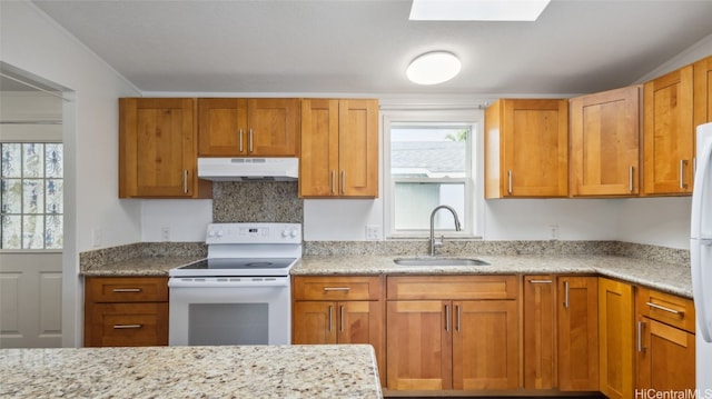 kitchen featuring light stone counters, sink, and white appliances