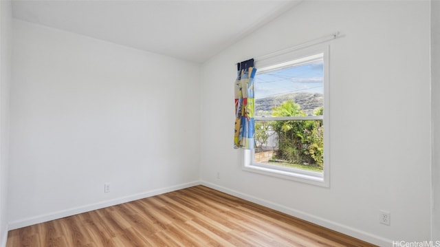 unfurnished room with light hardwood / wood-style flooring and vaulted ceiling