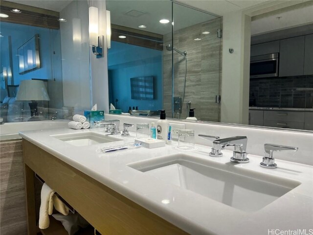 bathroom with hardwood / wood-style flooring, vanity, and walk in shower