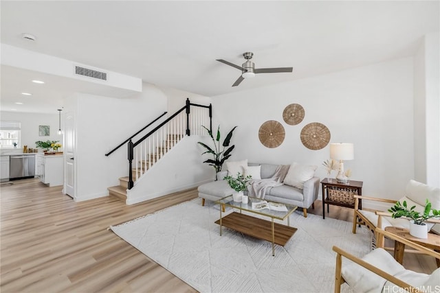 living room with ceiling fan and light hardwood / wood-style flooring