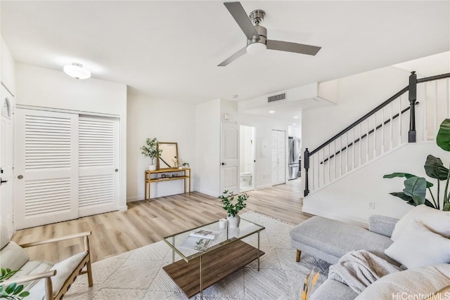 living room featuring light wood-type flooring and ceiling fan