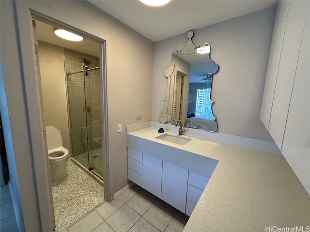 bathroom with toilet, vanity, tile patterned floors, and walk in shower