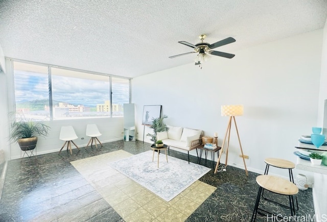 living area with a textured ceiling and ceiling fan