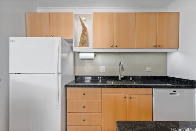 kitchen with a textured ceiling, white appliances, dark stone counters, and sink