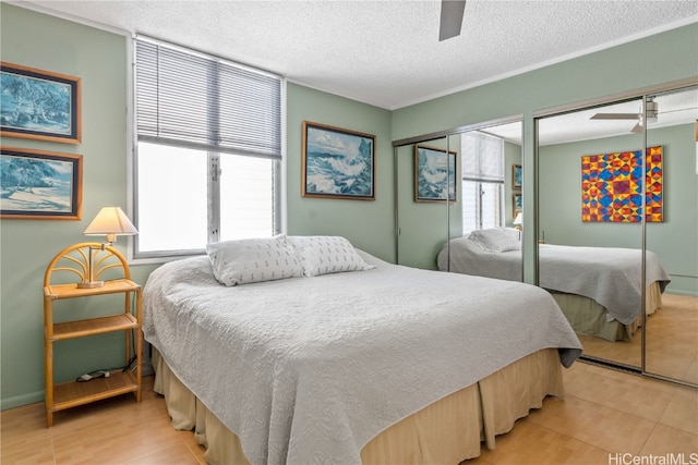 bedroom with two closets, ceiling fan, a textured ceiling, and hardwood / wood-style flooring