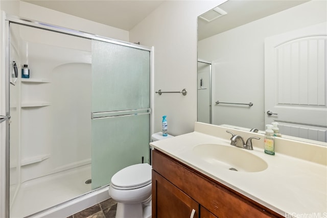 bathroom with vanity, toilet, and a shower with door