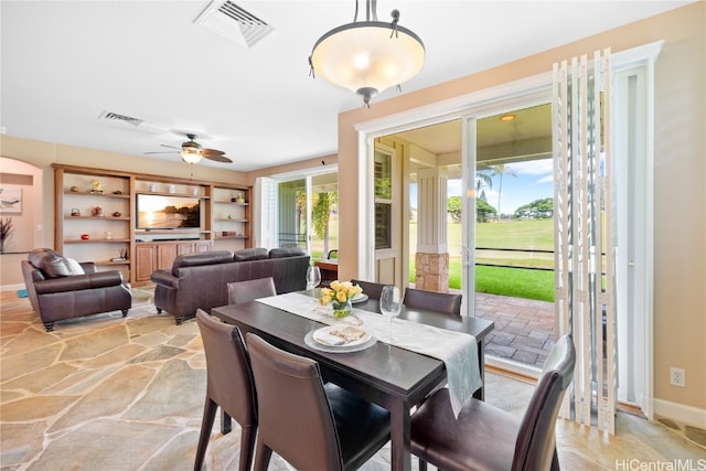 dining space featuring built in shelves and ceiling fan