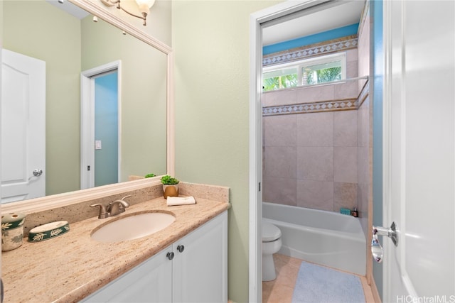 full bathroom with toilet, vanity, tiled shower / bath, and tile patterned flooring