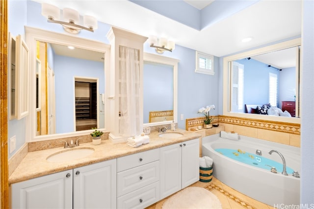 bathroom featuring a bathing tub, tile patterned flooring, and vanity