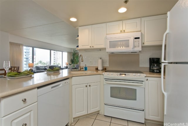 kitchen featuring sink, light tile patterned floors, tasteful backsplash, white appliances, and white cabinets