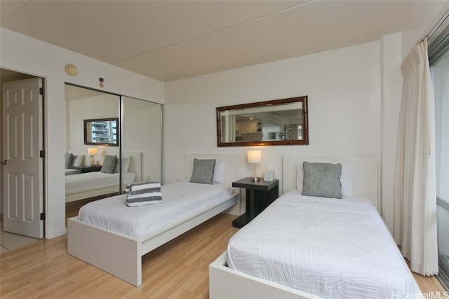 bedroom with light wood-type flooring and a closet