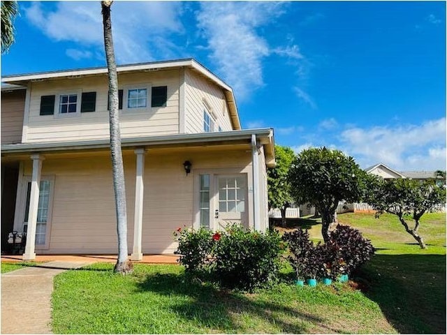 rear view of house featuring a lawn