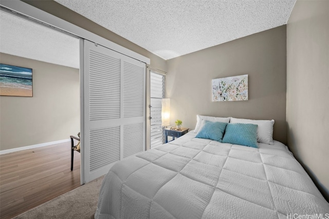 bedroom with hardwood / wood-style flooring, a textured ceiling, and a closet