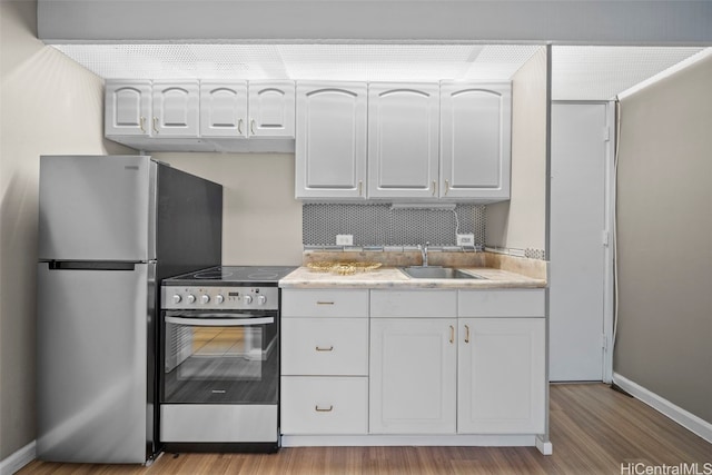 kitchen with white cabinetry, sink, light hardwood / wood-style flooring, and appliances with stainless steel finishes