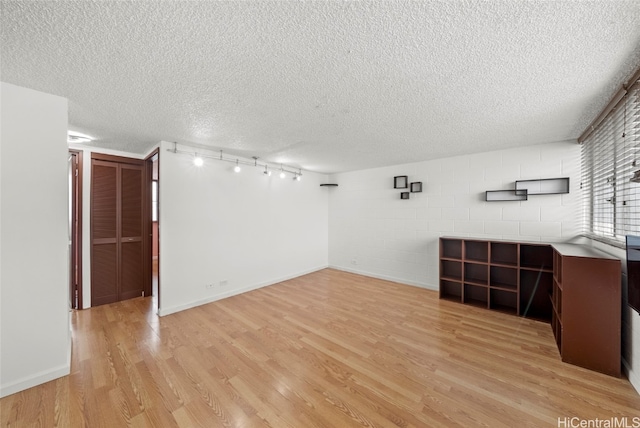 unfurnished room with a textured ceiling and light hardwood / wood-style floors