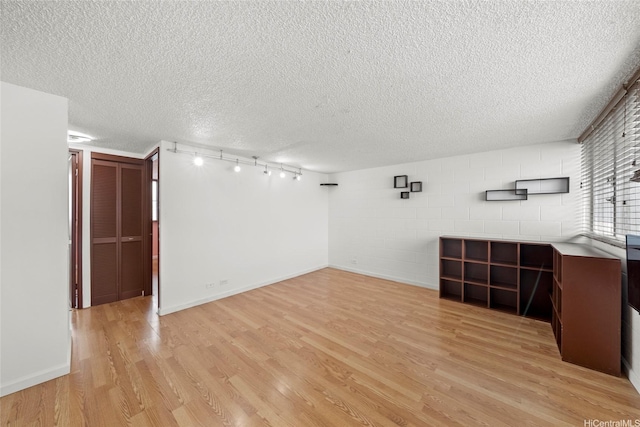 502 Captain Cook Ave Unit 303, Honolulu, HI 96813 - unfurnished living room featuring light wood-style floors, a textured ceiling, and concrete block wall