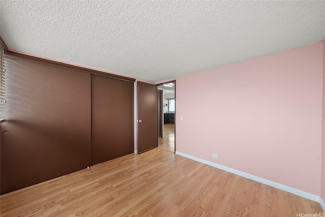 502 Captain Cook Ave Unit 303, Honolulu, HI 96813 - unfurnished bedroom with light wood-type flooring, a closet, and a textured ceiling