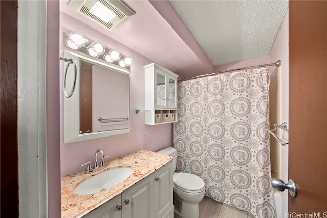 bathroom featuring a shower with shower curtain, a textured ceiling, vanity, hardwood / wood-style flooring, and toilet