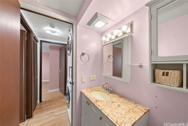 bathroom with washer / dryer, vanity, a textured ceiling, and hardwood / wood-style flooring