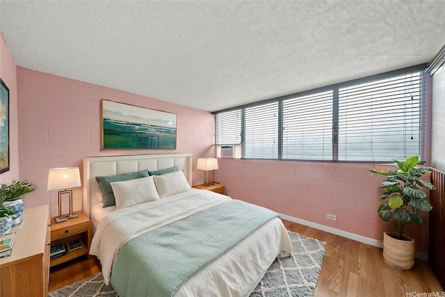 502 Captain Cook Ave Unit 303, Honolulu, HI 96813 - bedroom with concrete block wall, wood finished floors, and cooling unit