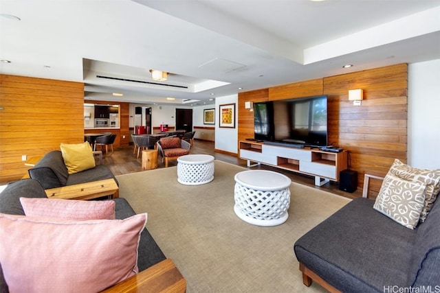 living room featuring a tray ceiling, pool table, hardwood / wood-style flooring, and wood walls