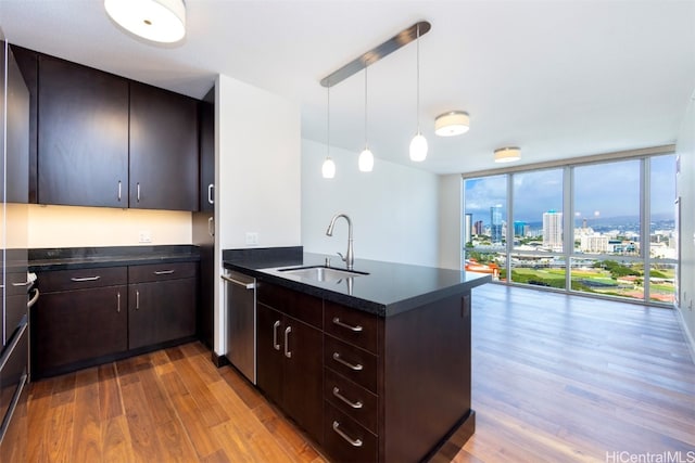 kitchen featuring sink, dark brown cabinetry, expansive windows, decorative light fixtures, and kitchen peninsula