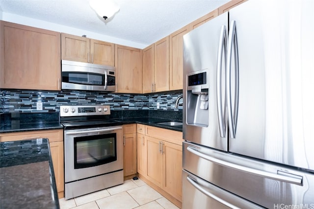 kitchen with stainless steel appliances, sink, backsplash, and light tile patterned floors