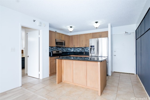 kitchen with sink, backsplash, appliances with stainless steel finishes, and a center island