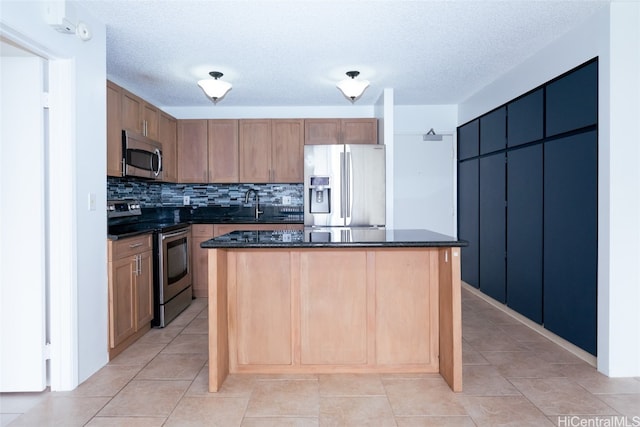 kitchen featuring decorative backsplash, a kitchen island, appliances with stainless steel finishes, and a textured ceiling