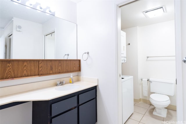 bathroom featuring toilet, vanity, tile patterned flooring, and stacked washer / drying machine