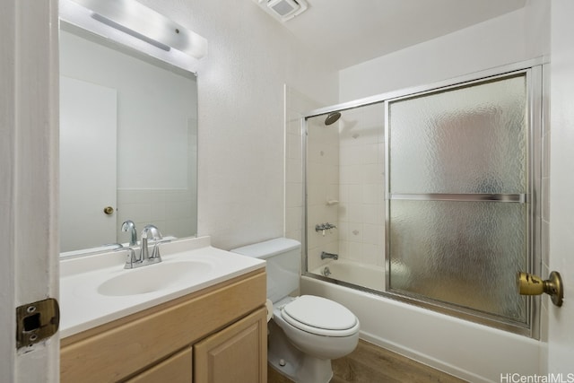 full bathroom featuring toilet, vanity, bath / shower combo with glass door, and hardwood / wood-style flooring