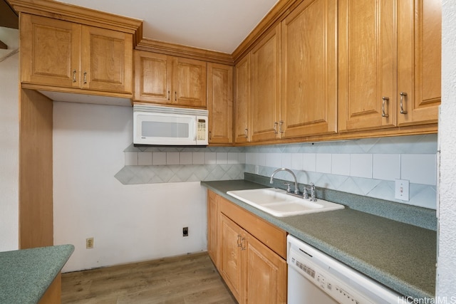 kitchen featuring light wood-type flooring, decorative backsplash, white appliances, and sink