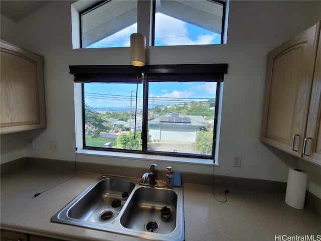 kitchen with light brown cabinets, sink, a wealth of natural light, and vaulted ceiling