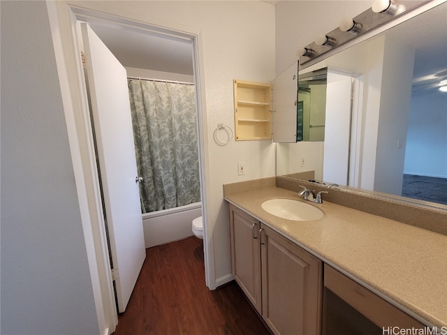 bathroom featuring shower / bathtub combination with curtain, vanity, toilet, and wood finished floors