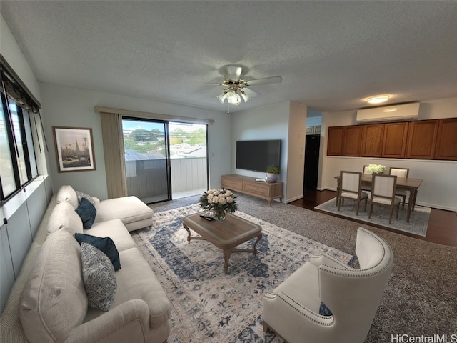 living room featuring a wall unit AC, a ceiling fan, and a textured ceiling