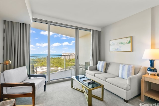 living room featuring carpet flooring, a water view, and floor to ceiling windows