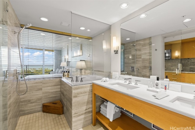 bathroom featuring shower with separate bathtub and sink