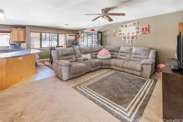 living room with a textured ceiling, light colored carpet, a wall mounted AC, and ceiling fan